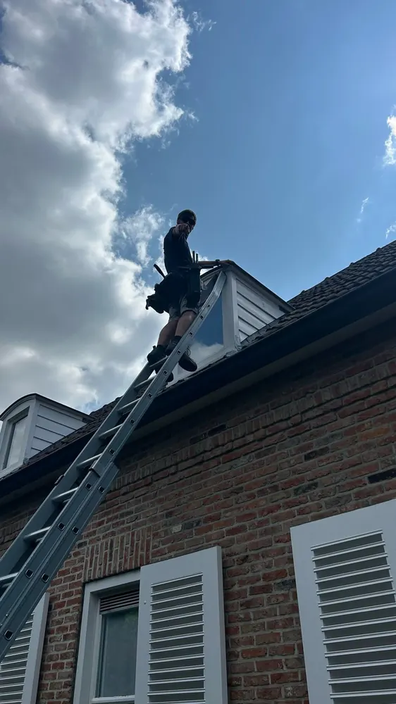 Ramenwasser op een ladder tegen een dak
